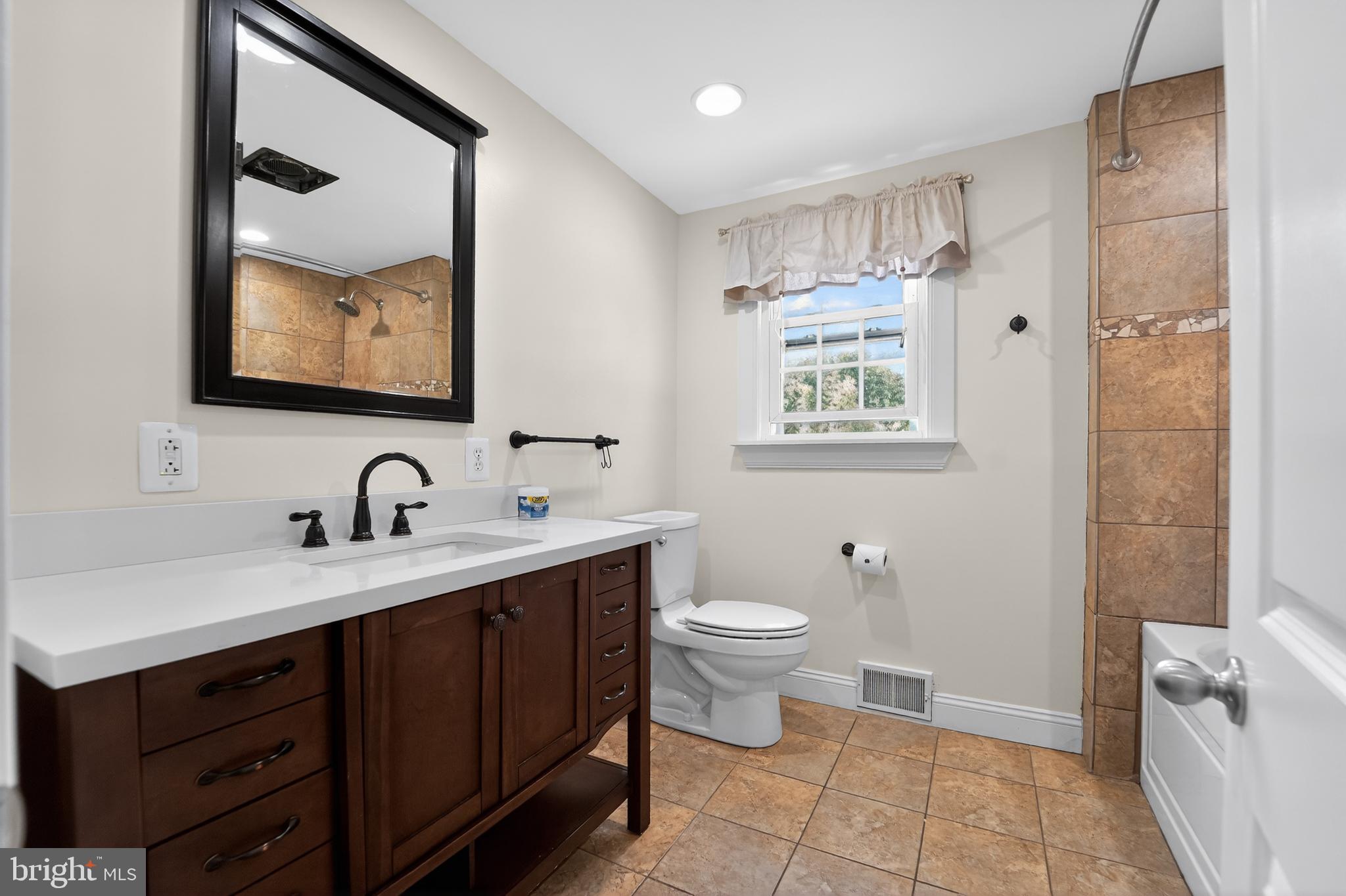 9408 Dana Vista Road Baltimore, MD 21236 - Photo 25 of 38 a bathroom with a toilet sink and mirror