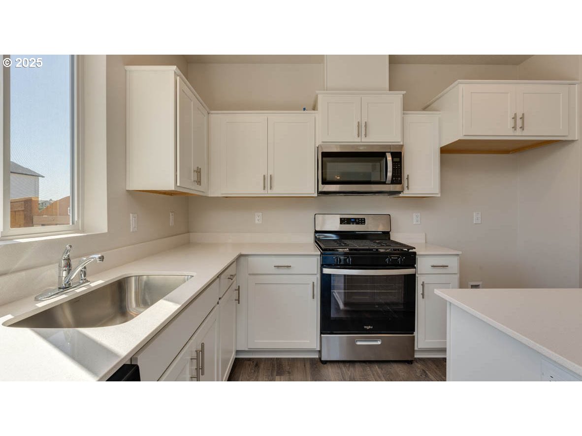 2873 V Street Springfield, OR 97477 - Photo 8 of 22 a kitchen with stainless steel appliances a stove sink microwave and cabinets