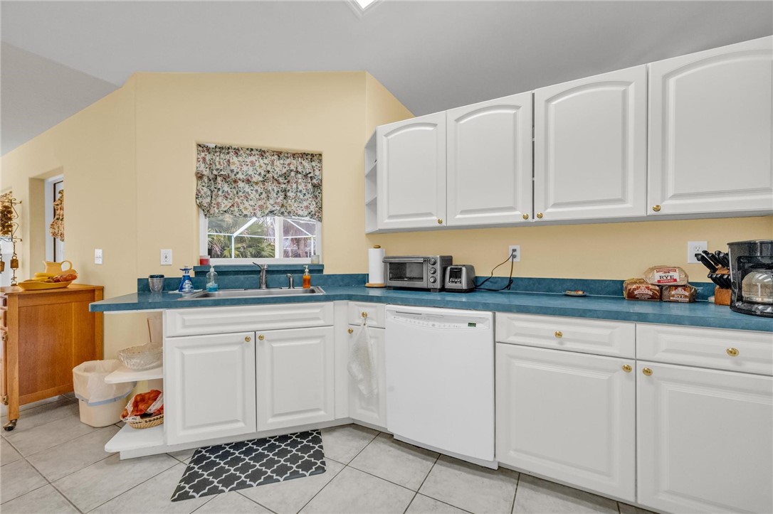 1641 Laconia Street Sebastian, FL 32958 - Photo 15 of 32 a kitchen with granite countertop white cabinets and white appliances