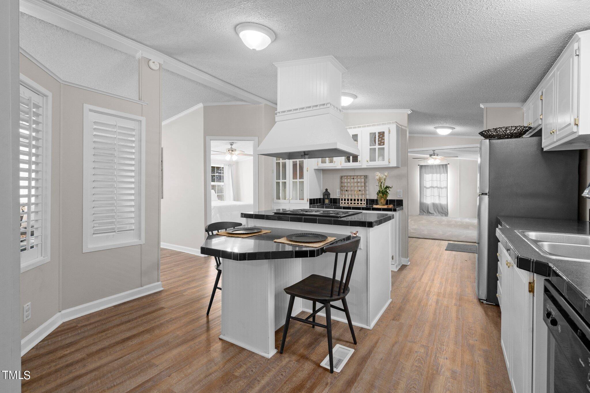 3420 Craven Road Middlesex, NC 27557 - Photo 11 of 31 a kitchen with stainless steel appliances granite countertop a stove a refrigerator a sink a dining table and chairs with wooden floor