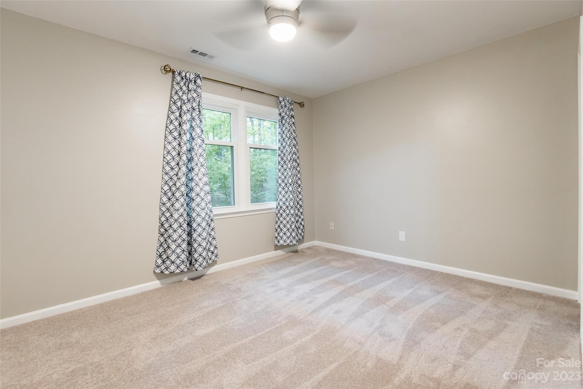 2117 Bon Villa Way Tega Cay, SC 29708 - Photo 16 of 25 an empty room with windows and chandelier fan