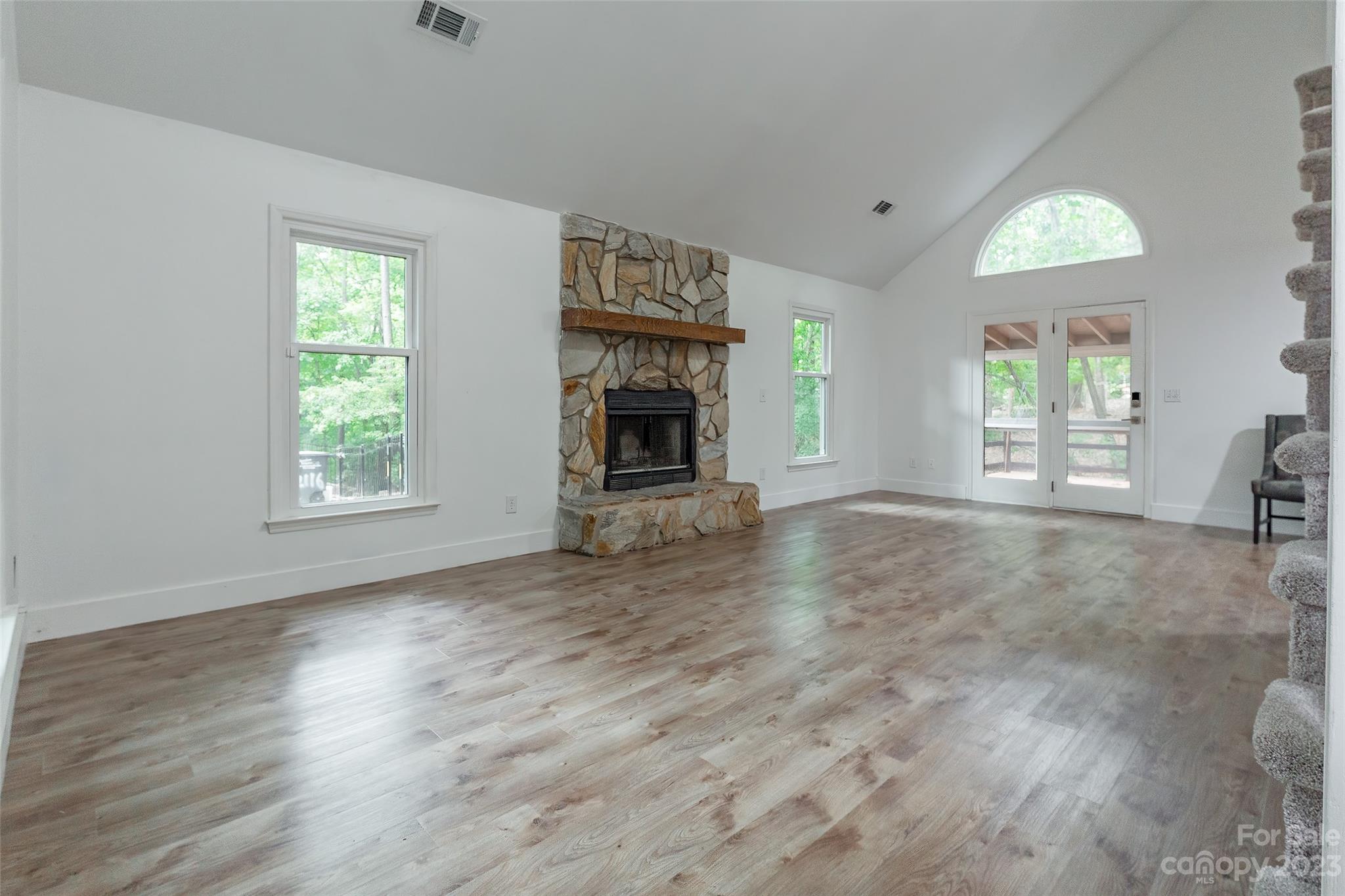2117 Bon Villa Way Tega Cay, SC 29708 - Photo 3 of 25 an empty room with windows fireplace and wooden floor