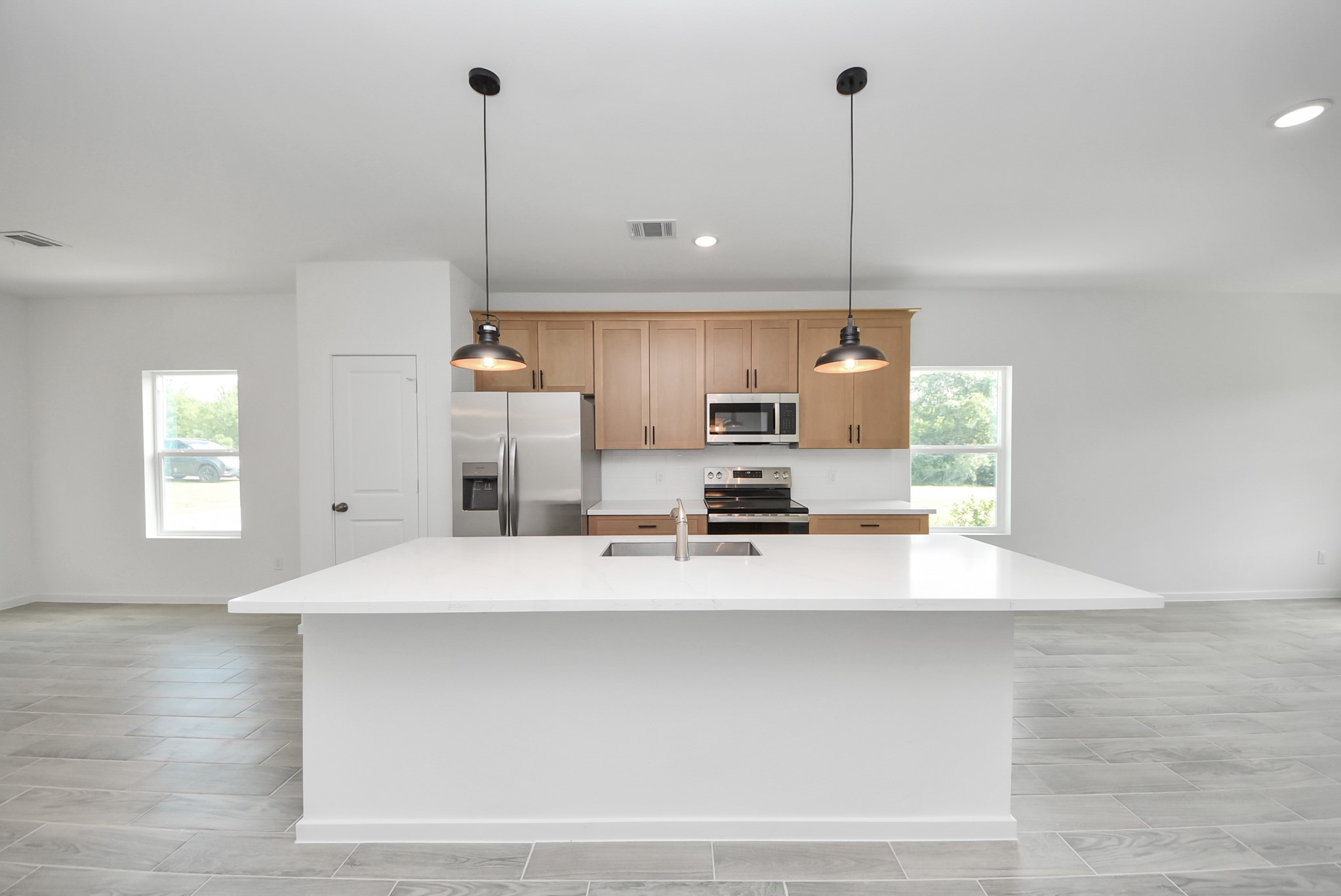 211 19th Street Hempstead, TX 77445 - Photo 7 of 32 Modern kitchen with white quartz countertops and ample cabinet space.