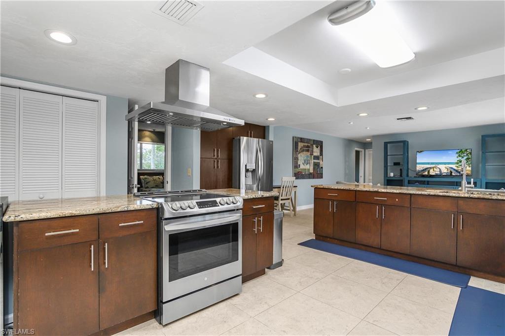 330 Country Club Drive Naples, FL 34110 - Photo 12 of 37 a kitchen with stainless steel appliances granite countertop a stove and a sink