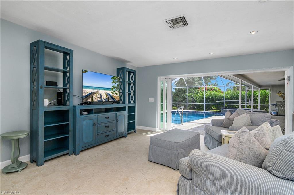 330 Country Club Drive Naples, FL 34110 - Photo 15 of 37 a living room with furniture and large windows