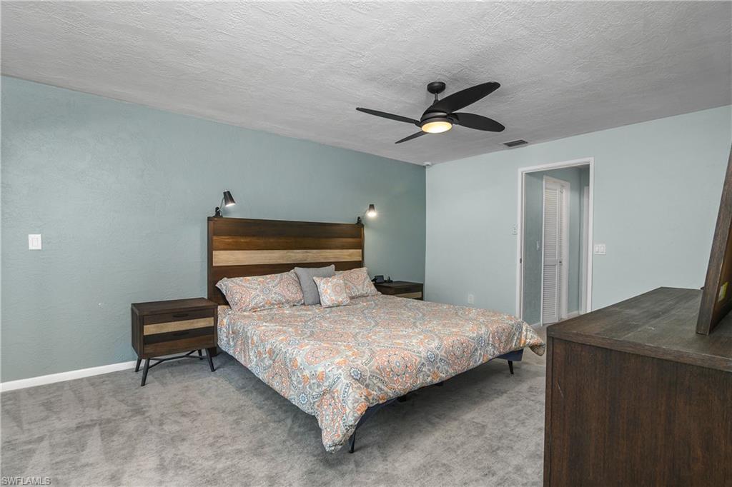 330 Country Club Drive Naples, FL 34110 - Photo 17 of 37 a bedroom with a bed and a chandelier