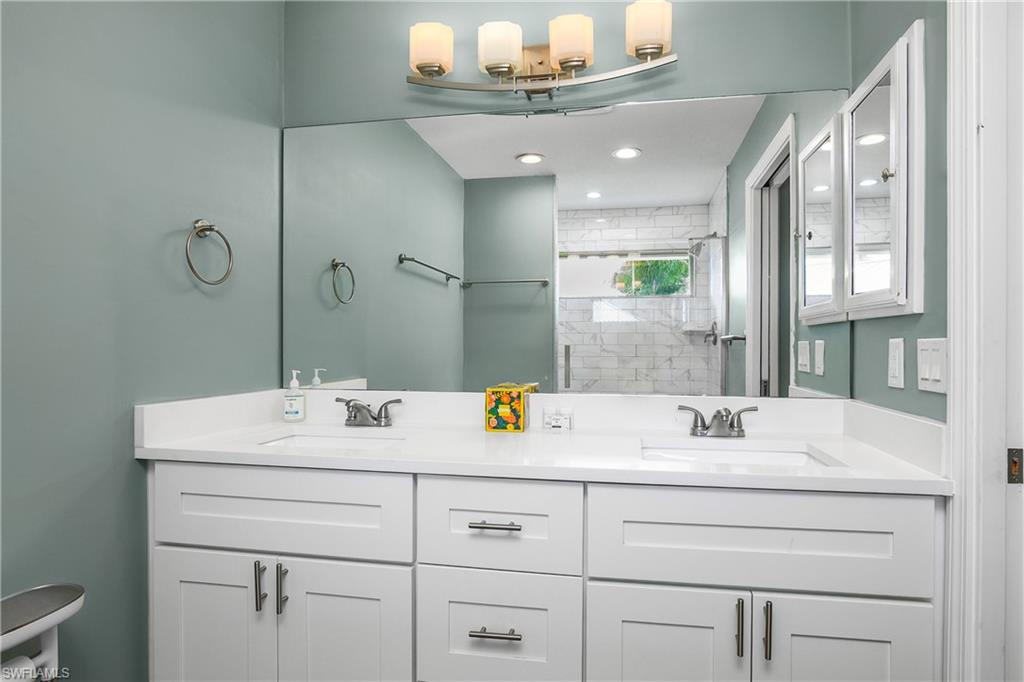 330 Country Club Drive Naples, FL 34110 - Photo 18 of 37 a bathroom with a sink double vanity granite and a mirror