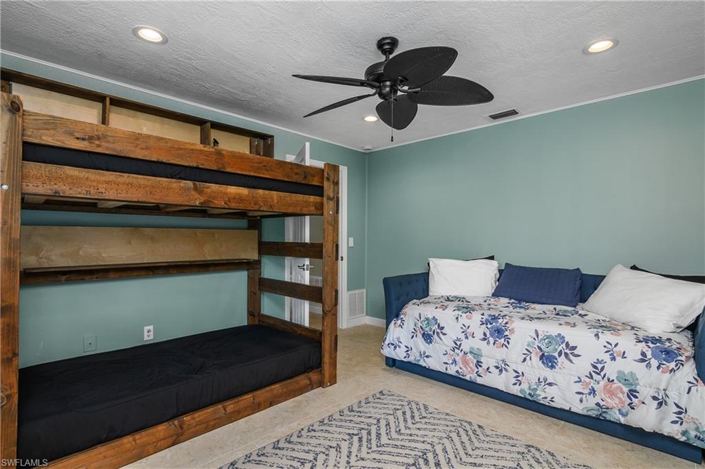 330 Country Club Drive Naples, FL 34110 - Photo 24 of 37 a bedroom with a bed and a chandelier