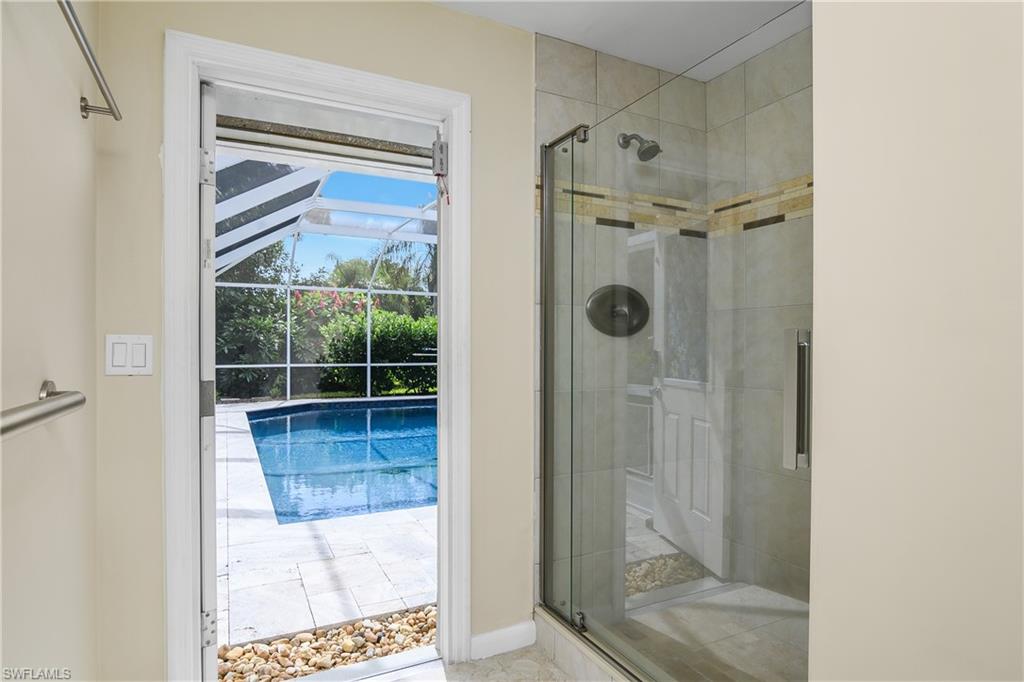 330 Country Club Drive Naples, FL 34110 - Photo 25 of 37 a bathroom with a glass shower door and a window