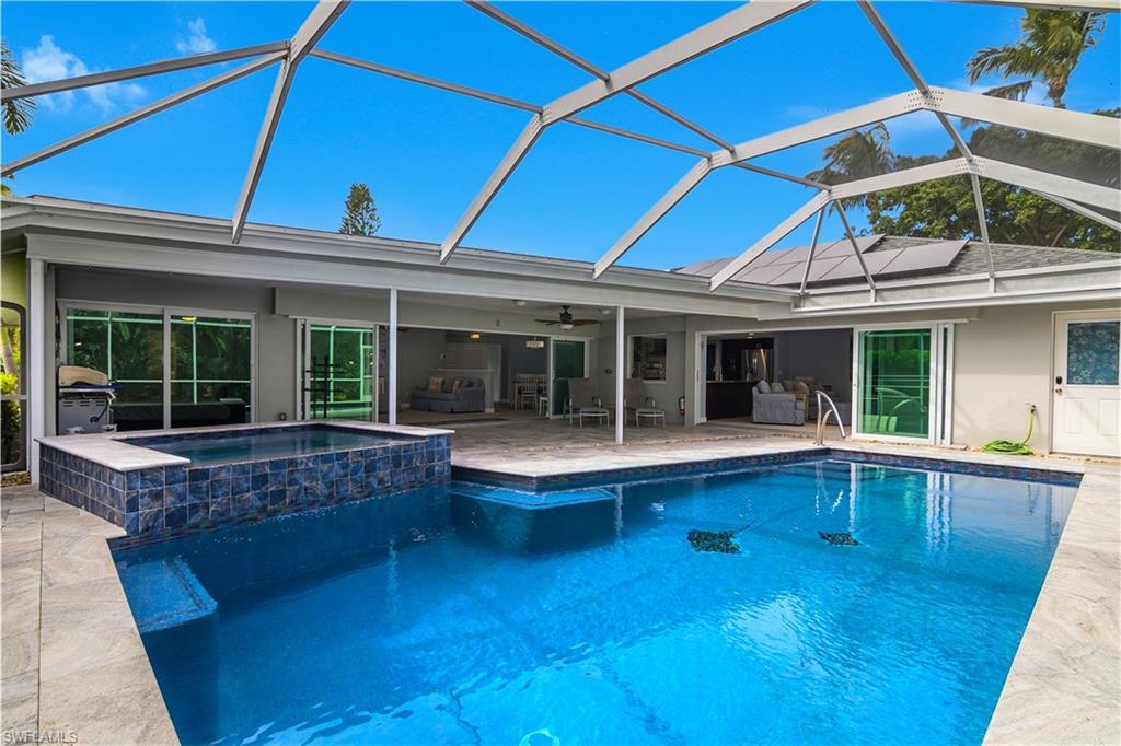 330 Country Club Drive Naples, FL 34110 - Photo 4 of 37 a view of a house with pool fire pit and wooden floor