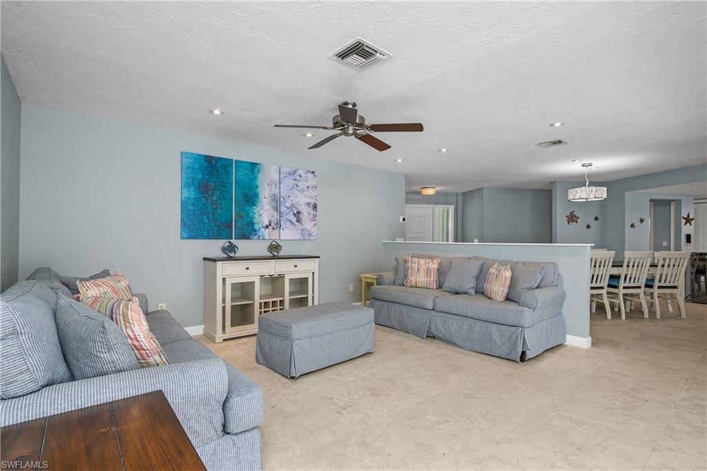 330 Country Club Drive Naples, FL 34110 - Photo 7 of 37 a living room with furniture and a chandelier