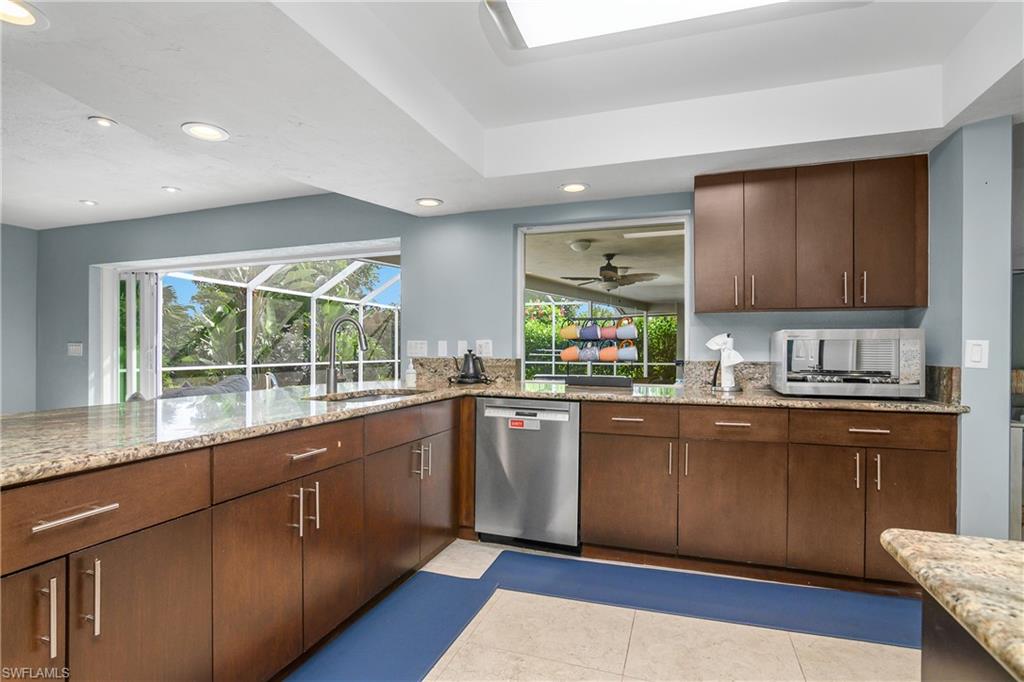 330 Country Club Drive Naples, FL 34110 - Photo 10 of 37 a kitchen with stainless steel appliances granite countertop a stove a sink and a microwave