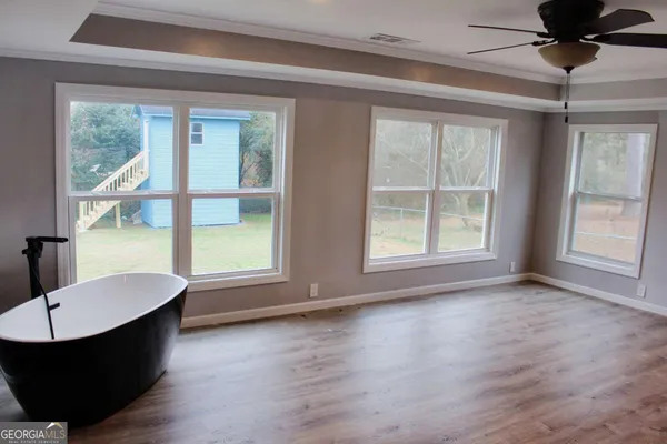 a living room with hardwood floor a ceiling fan and window