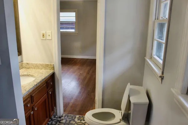 a bathroom with a granite countertop sink and a toilet