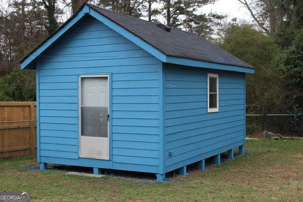 a view of wooden house and a yard