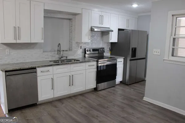 a kitchen with stainless steel appliances granite countertop a refrigerator sink and cabinets