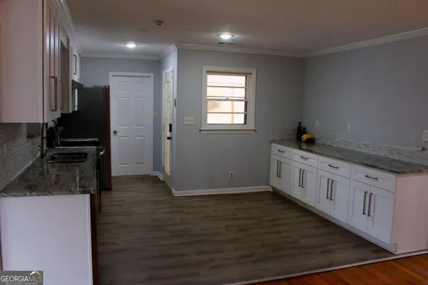 a kitchen with granite countertop white cabinets and stainless steel appliances