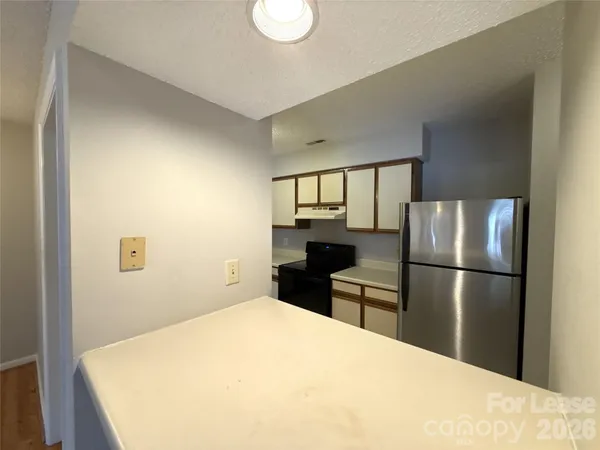 a kitchen with a refrigerator a stove top oven and a refrigerator