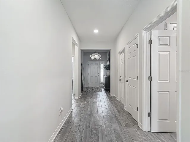 a kitchen with stainless steel appliances granite countertop a sink a stove a refrigerator cabinets and chairs