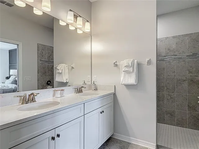 a bathroom with a granite countertop sink toilet tub and shower