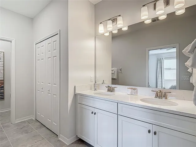 a bathroom with a granite countertop sink toilet and mirror
