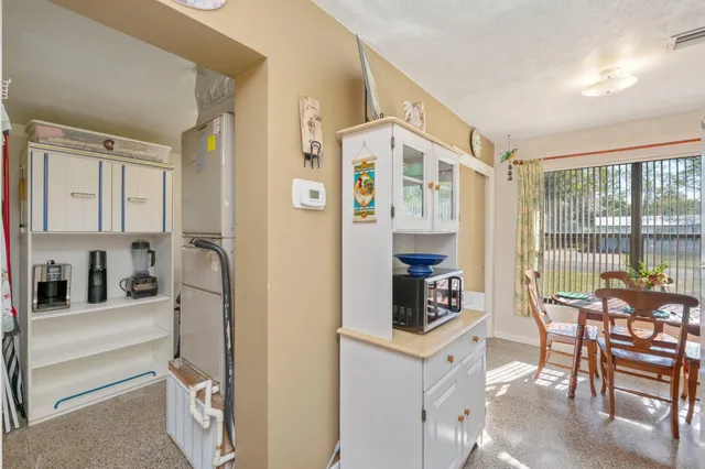 a kitchen with stainless steel appliances granite countertop a refrigerator and a dining table