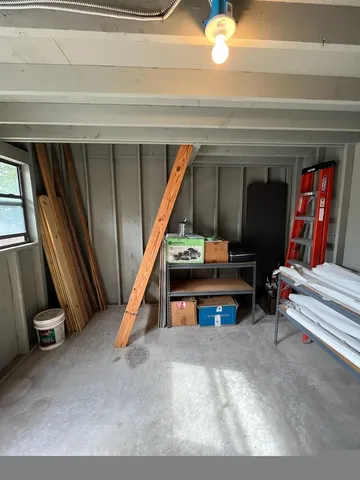 a view of an empty room with wooden floor and furniture