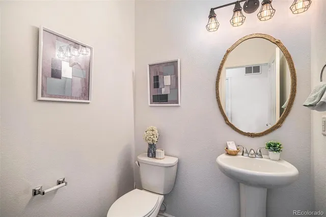 a bathroom with a toilet sink and mirror