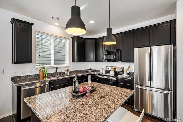 a kitchen with stainless steel appliances granite countertop a sink refrigerator and microwave