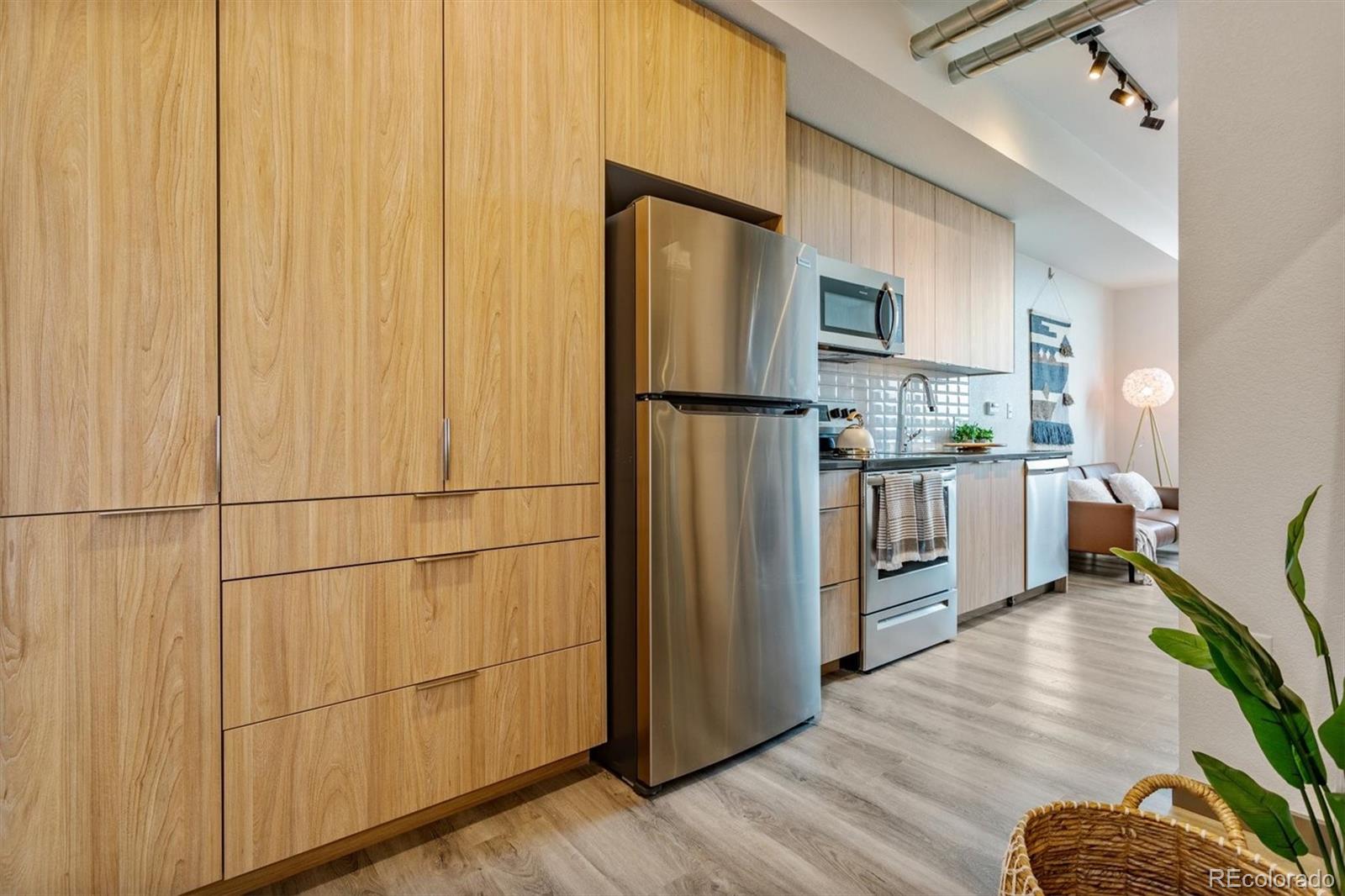 603 Inca Street, Unit 309 Denver, CO 80204 - Photo 14 of 27 a kitchen with stainless steel appliances a refrigerator and wooden floor