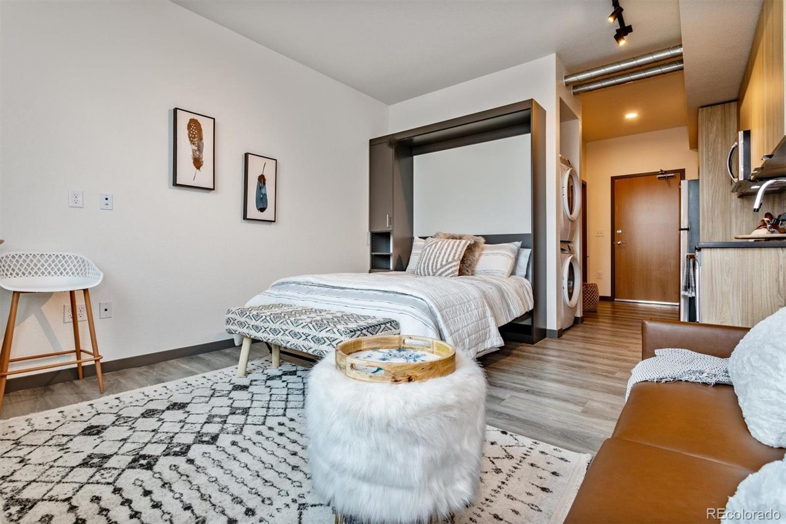 603 Inca Street, Unit 309 Denver, CO 80204 - Photo 15 of 27 a bedroom with a bed and a lamp with wooden floor