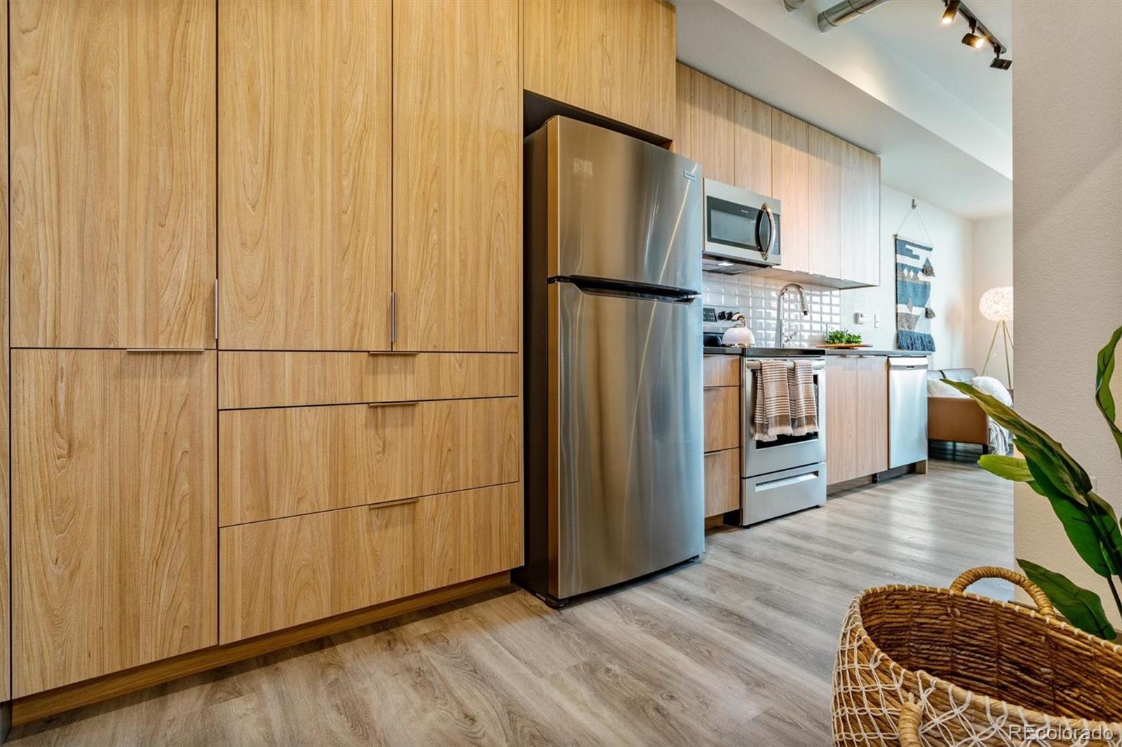 603 Inca Street, Unit 309 Denver, CO 80204 - Photo 25 of 27 a kitchen with stainless steel appliances granite countertop a refrigerator and a stove top oven