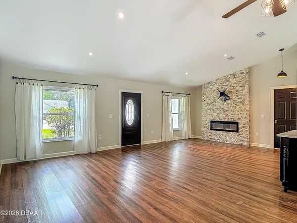 an empty room with wooden floor and window