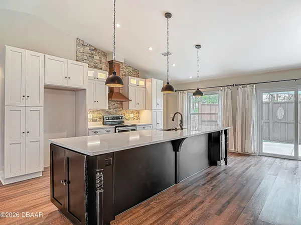 a kitchen with granite countertop a sink a counter space appliances and cabinets
