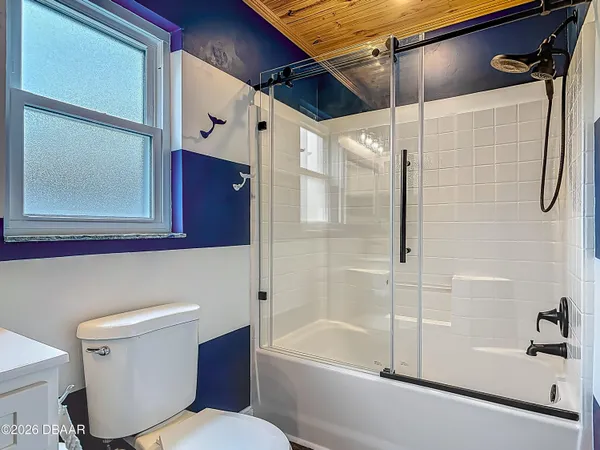 an empty room with wooden floor closet and windows