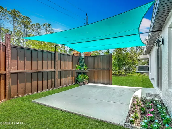 a view of a big yard with table and chairs potted plants