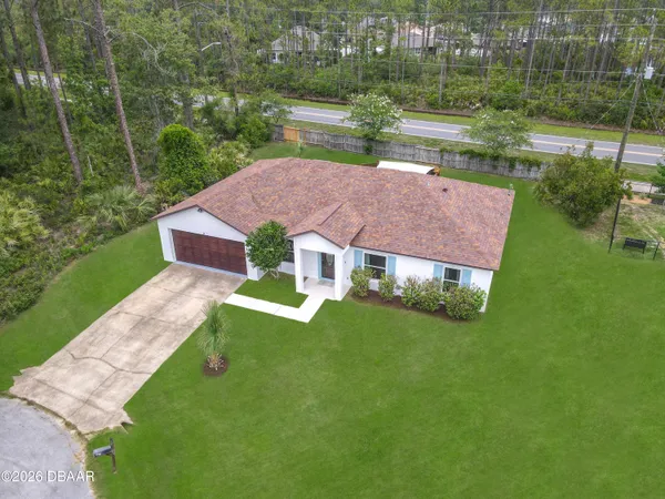 a front view of a house with a yard and green space