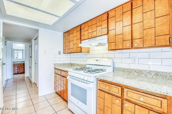 a kitchen with a sink refrigerator and cabinets