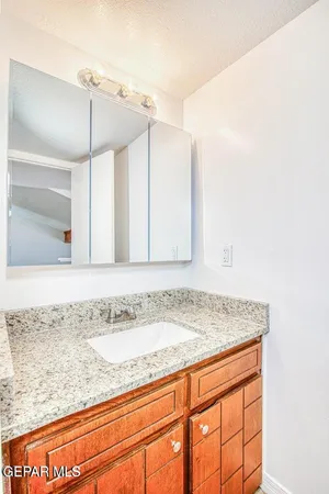 a bathroom with a granite countertop sink a toilet a mirror and bathtub