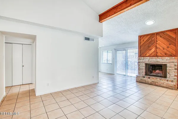 a view of an empty room with window and fire place