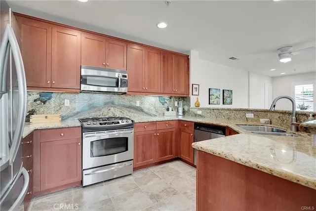 a kitchen with stainless steel appliances granite countertop a sink stove and microwave