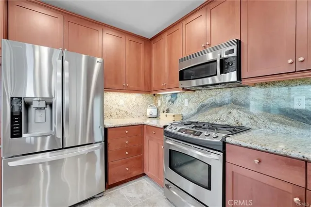 a kitchen with stainless steel appliances granite countertop a refrigerator stove and microwave