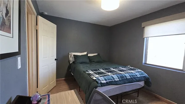a bedroom with a bed and a dresser with rug