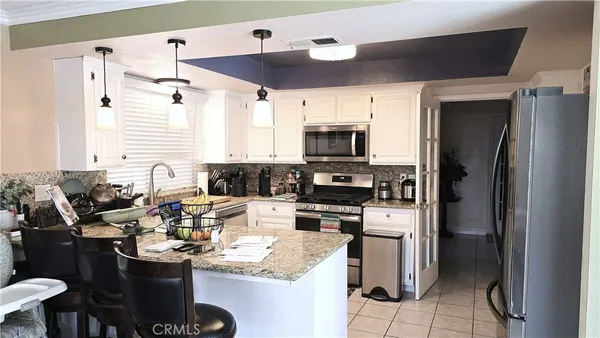 a kitchen with a sink stainless steel appliances and white cabinets