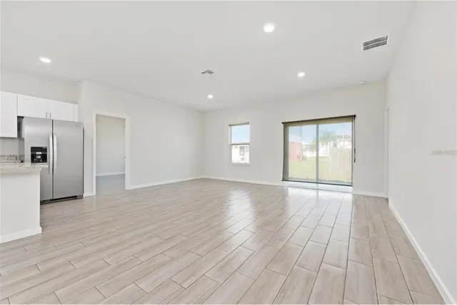 a view of empty room with wooden floor and window