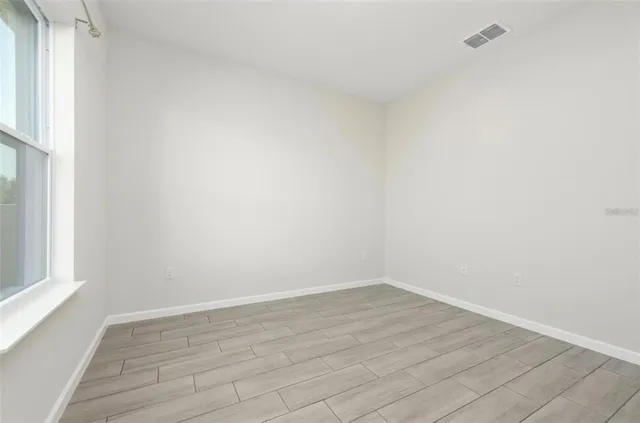 a view of a room that has wooden floor and bench in it