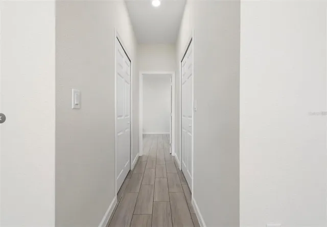 a view of a hallway with wooden floor