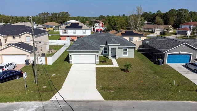 an aerial view of residential houses with outdoor space and parking