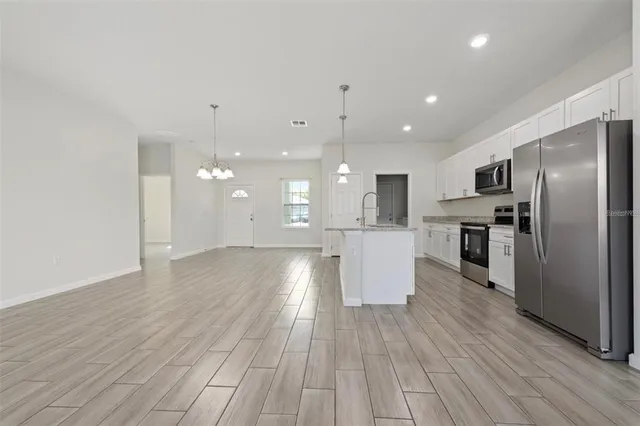 a view of kitchen view wooden floors appliances and cabinets
