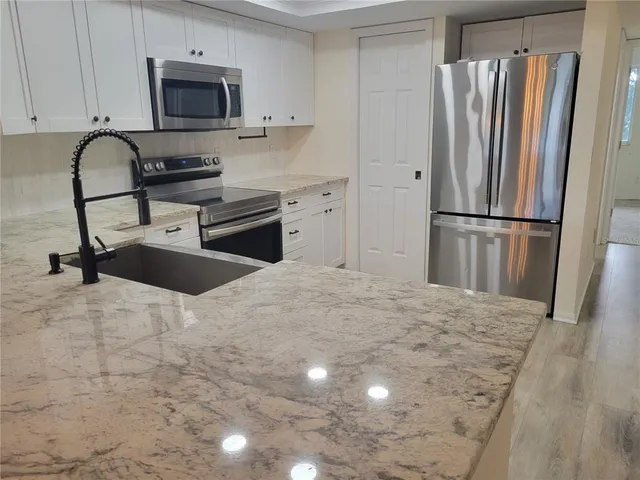 a kitchen with stainless steel appliances a refrigerator sink and cabinets